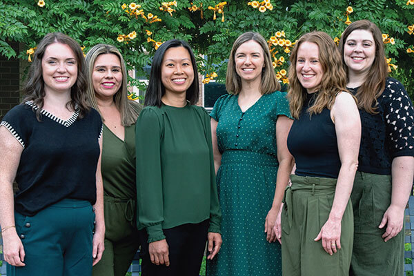 6 female Pre-Health Advisors posing for camera outside.