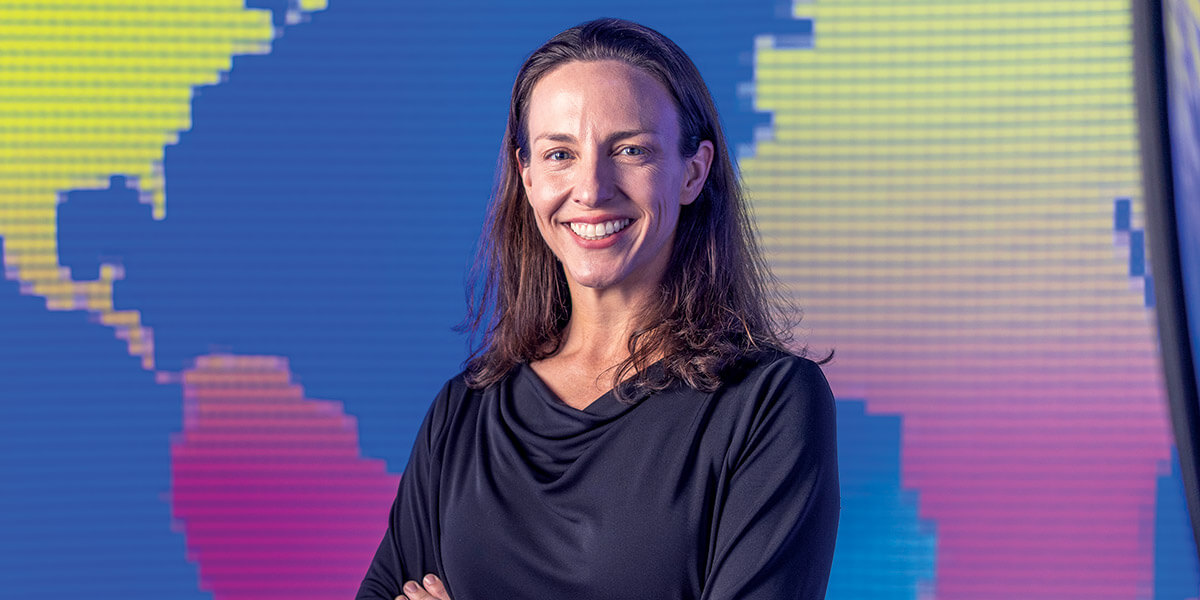 Photo of Lydia Beaudrot against a multi-color background of the globe.