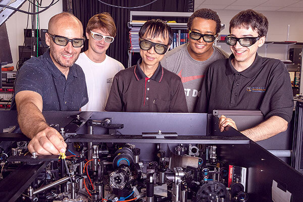 Tyler Cocker and lab members using a scanning tunneling microscope.
