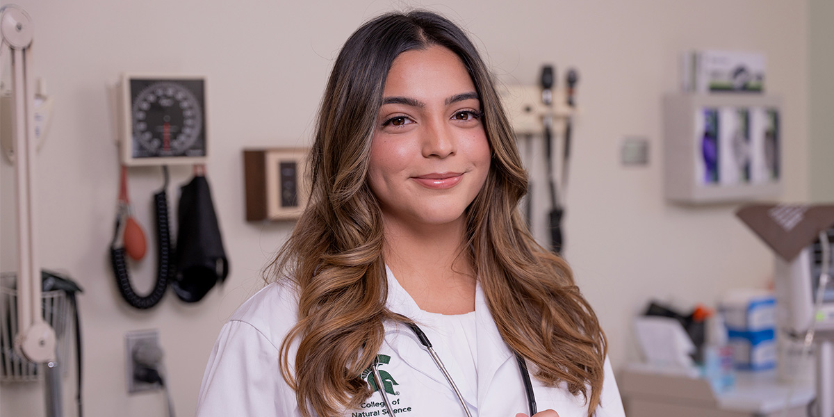Lizzie Ochoa posing for the camera in a doctors coat.